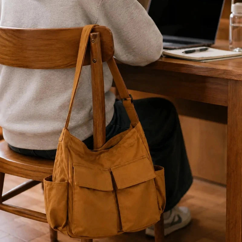 Sac cabas bandouliere marron accroché à une chaise de bibliothèque 