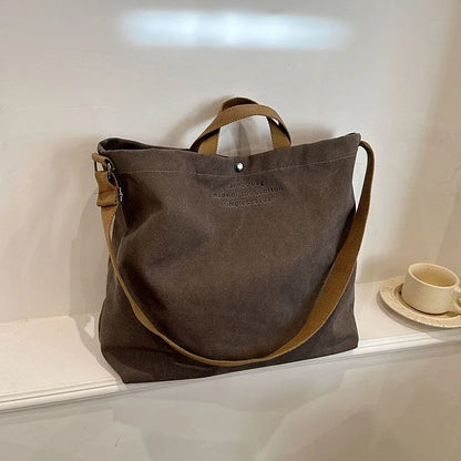 Sac cabas bandoulière en toile gris — posé sur meuble