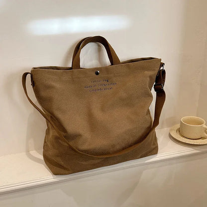 Sac cabas bandoulière en toile marron — posé sur meuble
