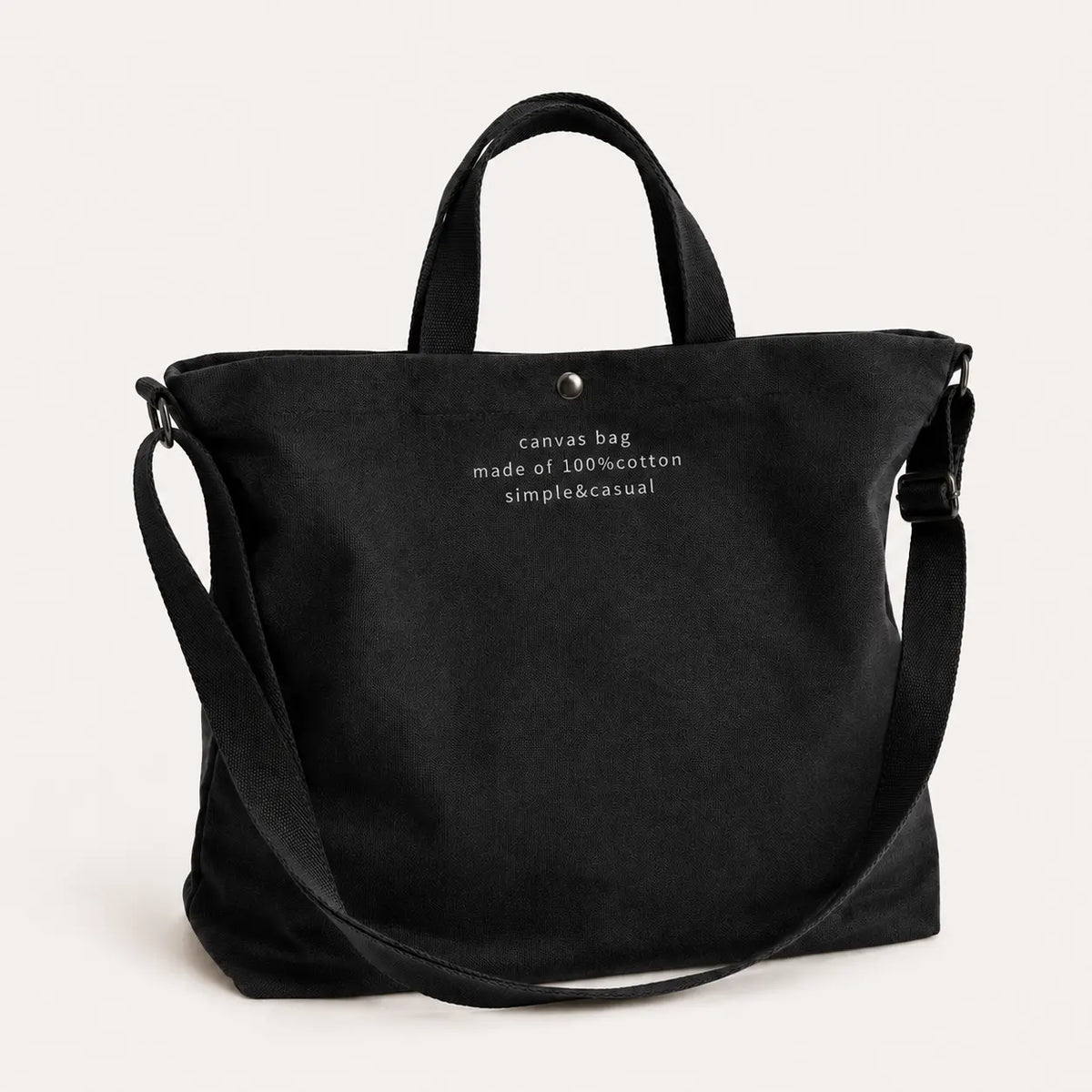 Sac cabas bandoulière en toile noir — posé sur meuble