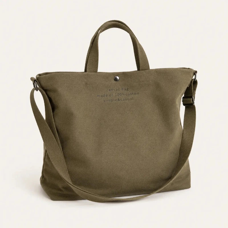 Sac cabas bandoulière en toile vert — posé sur meuble
