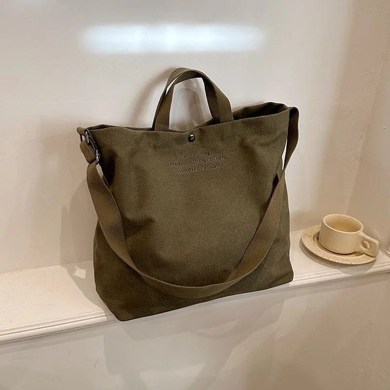 Sac cabas bandoulière en toile vert — posé sur meuble