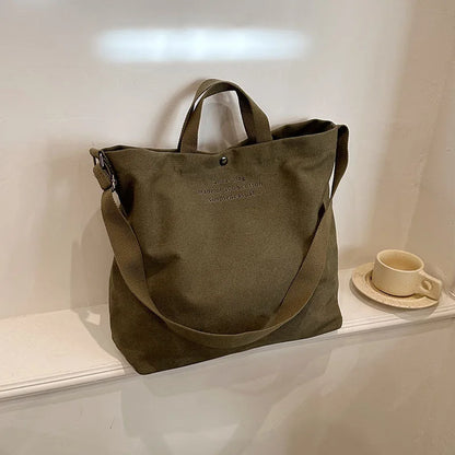 Sac cabas bandoulière en toile vert — posé sur meuble