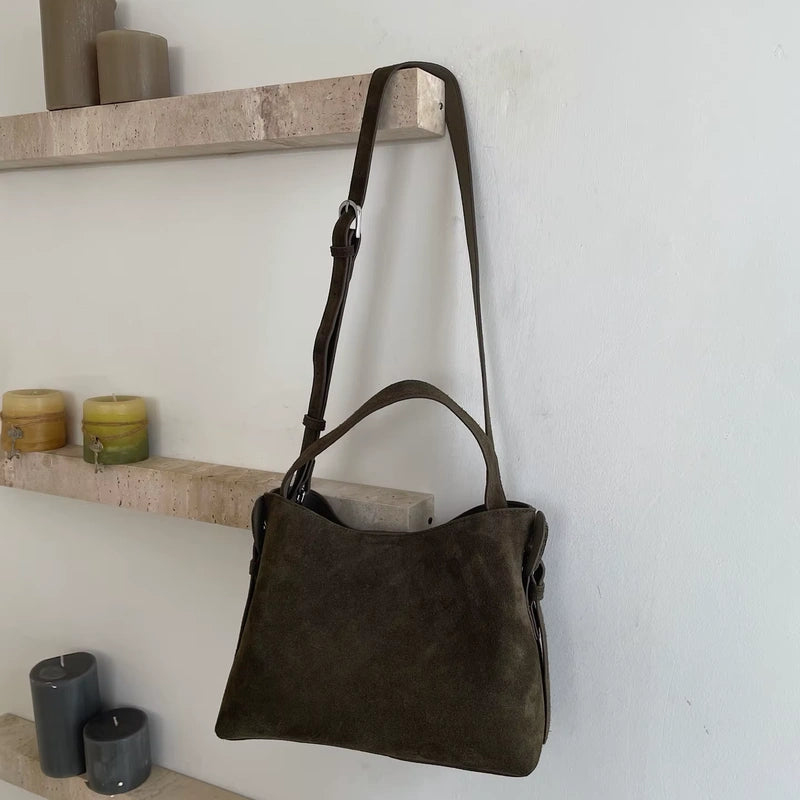 Sac cabas daim compact femme kaki suspendu devant des étagères