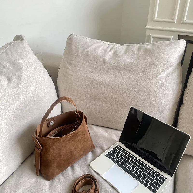 Sac cabas daim compact femme marron posé près d’un ordinateur
