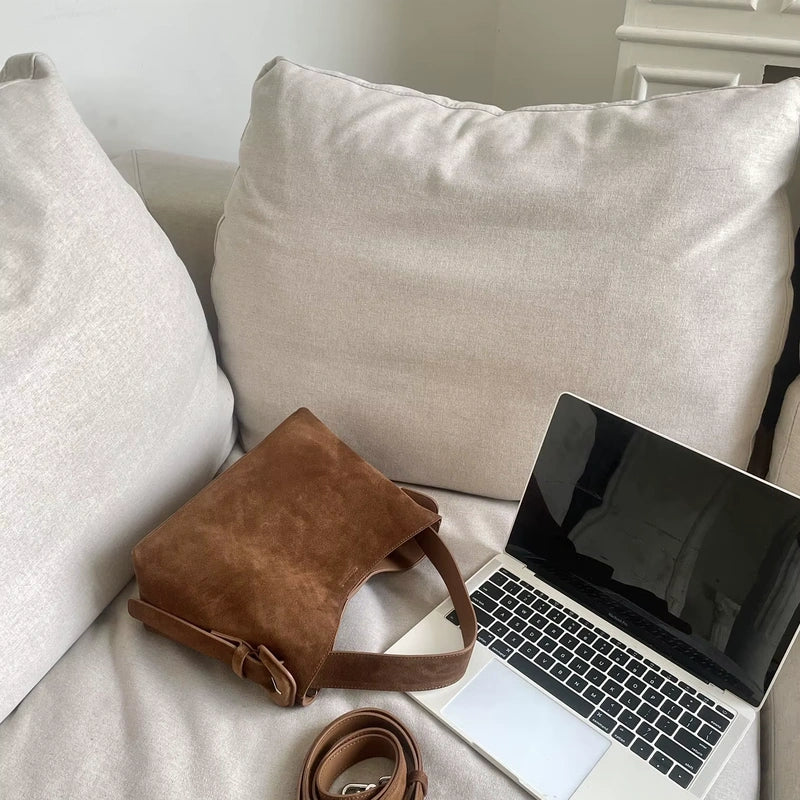 Sac cabas daim compact femme marron vu de côté près d’un ordinateur
