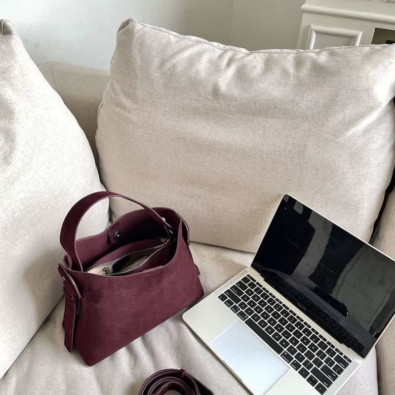 Sac cabas daim compact femme rouge ouvert près d’un ordinateur