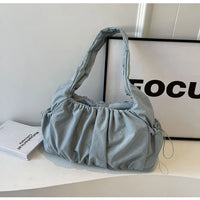 Sac cabas effet drape bleu — posé sur meuble en situation