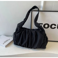 Sac cabas effet drape noir — posé sur meuble en situation