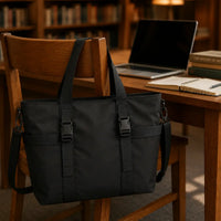 Sac cabas nylon imperméable noir suspendu au dossier d'une chaise en bibliothèque