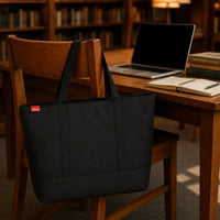 Sac cabas oxford grand format noir suspendu au dossier d'une chaise en bibliothèque