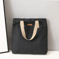 Sac cabas en toile bicolore noir — posé sur meuble