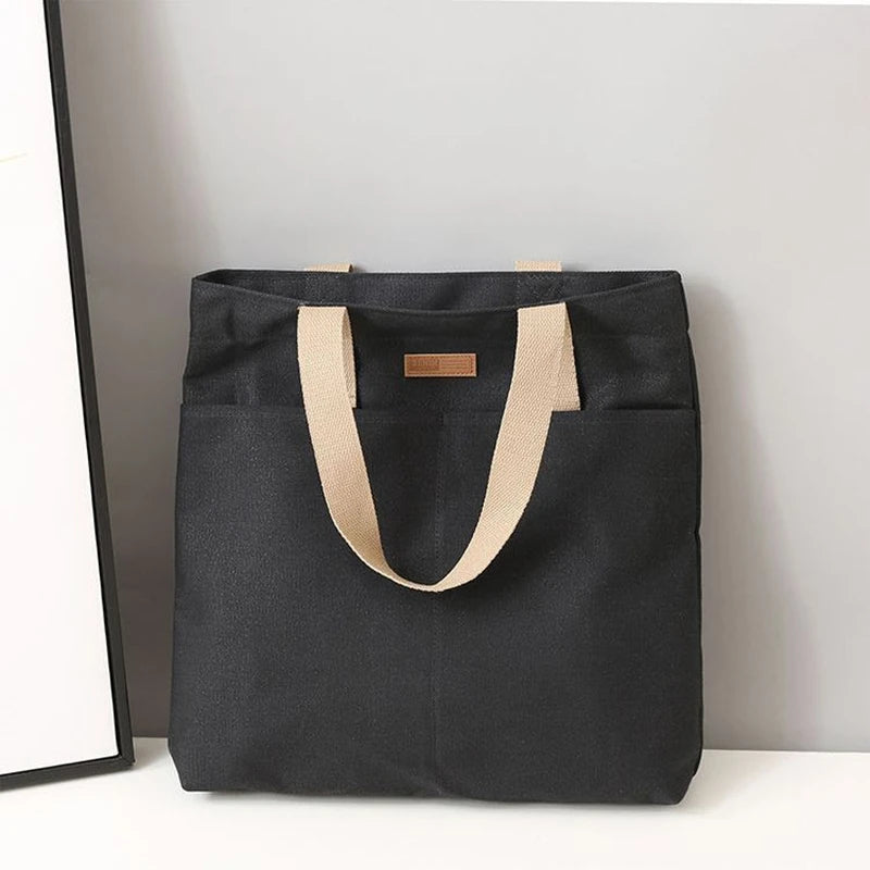 Sac cabas en toile bicolore noir — posé sur meuble