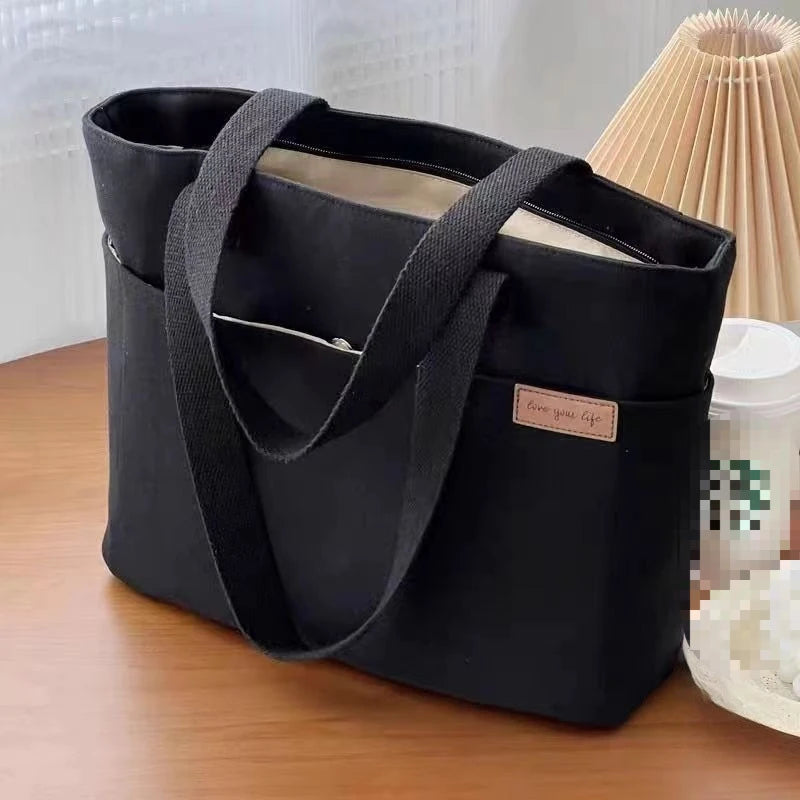 Sac cabas en toile minimaliste noir — posé sur meuble